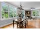 Bright dining room with large windows, hardwood floors, table with seating for six, and adjacent living room at 109 Henrys Ridge Rd, Pittsboro, NC 27312
