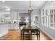Dining room with white walls, hardwood floors, table with seating for six, and adjacent kitchen and living room at 109 Henrys Ridge Rd, Pittsboro, NC 27312