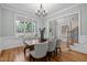 Bright dining room featuring hardwood floors, wainscoting, stylish chandelier, and natural light at 109 Henrys Ridge Rd, Pittsboro, NC 27312