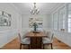 Formal dining room with hardwood floors, stylish chandelier, wainscoting and expansive windows at 109 Henrys Ridge Rd, Pittsboro, NC 27312