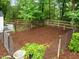 Fenced dog run area with wood chip ground cover and mature trees at 109 Henrys Ridge Rd, Pittsboro, NC 27312