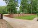 Gated driveway featuring a lushly landscaped yard with privacy fence and mature trees at 109 Henrys Ridge Rd, Pittsboro, NC 27312