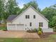 Back exterior view of a home featuring a three car garage, white shingles, and mature trees at 109 Henrys Ridge Rd, Pittsboro, NC 27312