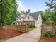 Two-story home featuring a stone and white shingle exterior, three car garage, mature trees and a gated drive at 109 Henrys Ridge Rd, Pittsboro, NC 27312