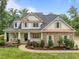 Charming two-story home with a welcoming front porch, stone accents, and beautifully landscaped yard at 109 Henrys Ridge Rd, Pittsboro, NC 27312