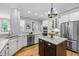 Bright kitchen with granite counters, stainless appliances, white cabinets, hardwood floors, and a center island at 109 Henrys Ridge Rd, Pittsboro, NC 27312