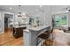 Open-concept kitchen with breakfast bar, white cabinets, hardwood floors, and access to the adjacent living room at 109 Henrys Ridge Rd, Pittsboro, NC 27312