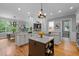 Open-concept kitchen with a center island, white cabinets, and hardwood floors open to the dining and living areas at 109 Henrys Ridge Rd, Pittsboro, NC 27312