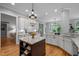 Bright kitchen features white cabinetry, granite counters, stainless sink, and a dark wood center island with shelving at 109 Henrys Ridge Rd, Pittsboro, NC 27312