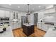 Modern kitchen features white cabinetry, a dark center island, and stainless steel appliances at 109 Henrys Ridge Rd, Pittsboro, NC 27312