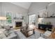 Bright living room with vaulted ceiling, fireplace, and large windows, seamlessly connecting to the dining area at 109 Henrys Ridge Rd, Pittsboro, NC 27312