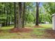Lush backyard with mature trees on a sunny day at 111 S Gaylee Lake Dr, Wendell, NC 27591