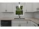 Close-up of bright kitchen featuring white cabinets, granite countertops, and stainless steel appliances at 111 S Gaylee Lake Dr, Wendell, NC 27591