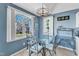 The dining area has a modern chandelier, a glass table and views of the backyard at 11113 N Radner Way, Raleigh, NC 27613