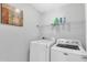 Well-lit laundry room is equipped with washer, dryer, shelving, and an art piece at 11113 N Radner Way, Raleigh, NC 27613
