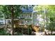 Back exterior shows a multi-level deck featuring a screened-in porch, all embraced by verdant foliage and towering trees at 113 Bergeron Way, Cary, NC 27519