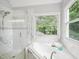 Beautiful bathroom featuring a shower with glass door and soaking tub under a window at 113 Bergeron Way, Cary, NC 27519
