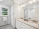 Bright bathroom features dual sinks, a large mirror, gray tile floor, and granite countertops at 113 Bergeron Way, Cary, NC 27519