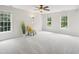 Spacious bedroom featuring three large windows, ceiling fan, and comfortable sitting area at 113 Bergeron Way, Cary, NC 27519