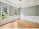 Formal dining room with classic chandelier, chair rail, and large windows bringing in natural light at 113 Bergeron Way, Cary, NC 27519