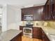 A stylish kitchen features granite counters, dark cabinets, stainless appliances, and hardwood floors at 113 Bergeron Way, Cary, NC 27519