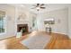 Comfortable living room with fireplace, hardwood floors, and modern ceiling fan at 113 Bergeron Way, Cary, NC 27519