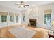Light-filled living room with fireplace, hardwood floors, and access to outdoor deck at 113 Bergeron Way, Cary, NC 27519