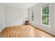 Sunlit living room with hardwood floors, two windows and decorative basket at 113 Bergeron Way, Cary, NC 27519