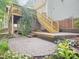 A stone patio and deck featuring stairs leading to the upper level with mature landscaping at 113 Bergeron Way, Cary, NC 27519