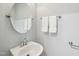 Charming powder room featuring a round mirror, updated faucet, and wall-mounted towel racks at 113 Bergeron Way, Cary, NC 27519
