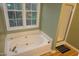 Bathroom featuring a bathtub, shower, and a window for natural light at 114 Calebra Way, Cary, NC 27519