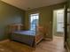 Cozy bedroom featuring hardwood floors, a wooden bed frame, and a window overlooking the neighborhood at 114 Calebra Way, Cary, NC 27519