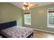 Bedroom featuring a bed with a floral comforter, two windows and a ceiling fan at 114 Calebra Way, Cary, NC 27519