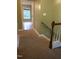 Hallway that features carpeted floors, stairs and white base-molding. Window at the end of the hall at 114 Calebra Way, Cary, NC 27519