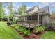 Exterior view of the landscaped backyard featuring a deck, screened porch and grilling area at 114 Margaret Mann Way, Pittsboro, NC 27312