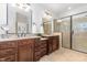 Double vanity bathroom featuring granite countertops, dark wood cabinets, and a glass-enclosed shower at 114 Margaret Mann Way, Pittsboro, NC 27312
