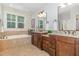 Double vanity bathroom featuring granite countertops, dark wood cabinets, and a separate tub at 114 Margaret Mann Way, Pittsboro, NC 27312