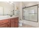 Well-lit bathroom featuring a cherry vanity, framed mirror and a glass enclosed tub and shower combination at 114 Margaret Mann Way, Pittsboro, NC 27312