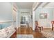 Hallway featuring hardwood floors, wainscoting, and open doorways that lead into other living spaces at 114 Margaret Mann Way, Pittsboro, NC 27312