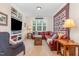 Cozy living room featuring a red sectional, built-in bookshelves and a large window at 114 Margaret Mann Way, Pittsboro, NC 27312