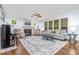 Cozy living room with a fireplace, plush seating, large windows, and a ceiling fan at 114 Margaret Mann Way, Pittsboro, NC 27312