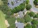 A high-angle shot showing a house with a patio and outdoor fireplace, backed by lush trees and a golf course at 1300 Heritage Club Ave, Wake Forest, NC 27587