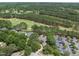 An aerial shot showing properties nestled among trees, near a golf course and parking area at 1300 Heritage Club Ave, Wake Forest, NC 27587