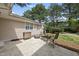 Private backyard featuring a stone patio, dining set and mature landscaping at 1300 Heritage Club Ave, Wake Forest, NC 27587