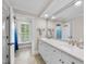 Bathroom featuring a dual sink vanity, large mirror and adjacent room with a window at 1300 Heritage Club Ave, Wake Forest, NC 27587