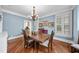 This dining room features a classic chandelier, beautiful wood floors, and large window at 1300 Heritage Club Ave, Wake Forest, NC 27587