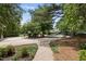 View of home from circular driveway lined with mature trees and well-maintained landscaping at 1300 Heritage Club Ave, Wake Forest, NC 27587