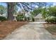 Stately home showcasing a three-car garage, mature landscaping, and charming curb appeal at 1300 Heritage Club Ave, Wake Forest, NC 27587