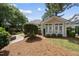 Exterior view of home with neat landscaping, a stone fire pit and a small sunroom at 1300 Heritage Club Ave, Wake Forest, NC 27587