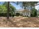 Exterior view showcasing the sunroom and the surrounding trees and landscaping at 1300 Heritage Club Ave, Wake Forest, NC 27587